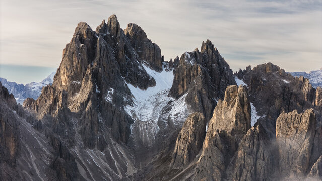 Aerial view of the jagged peaks of the Cadini group with snow in the crevices under a soft sky in Auronzo di Cadore, Veneto, Italy.