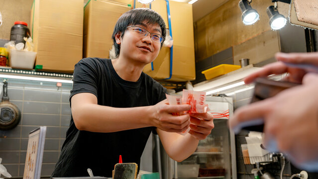 Vendor taking cash at Taiwanese night street food market
