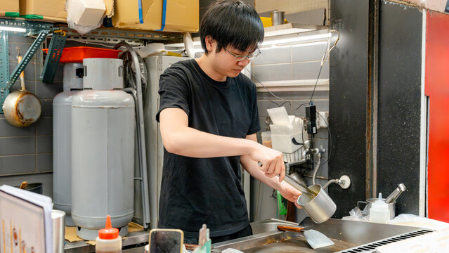 Taiwanese street food vendor cooking at night market stall