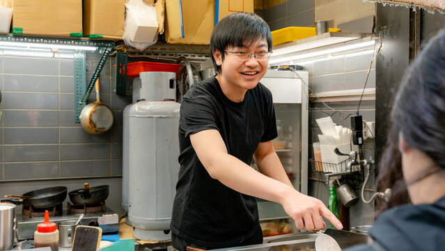 Taiwanese street vendor cooking at a night food market