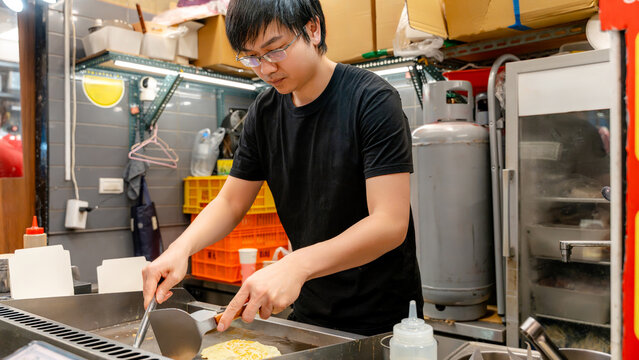 Taiwanese night market vendor cooking scallion pancake