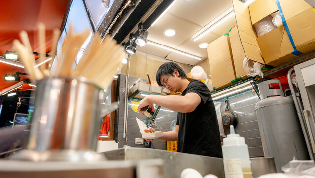 Taiwanese street food vendor preparing snack at night market