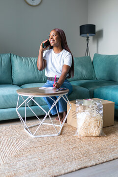 Black woman planning secondhand sale on mobile app at home