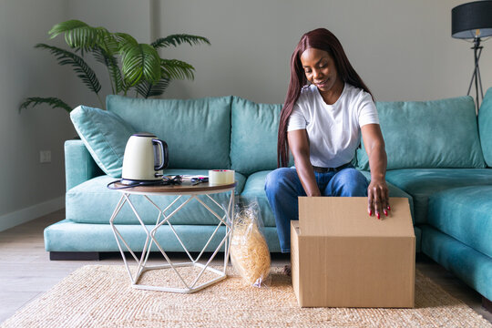 Black woman unpacking thrift purchase from secondhand app