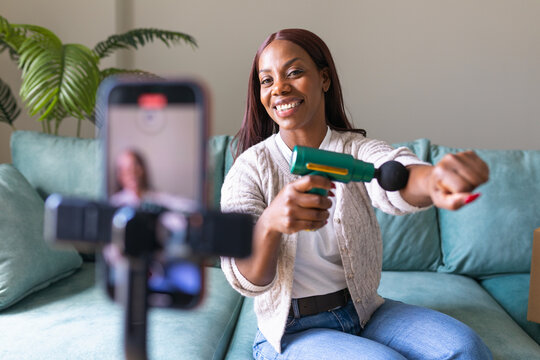 Black woman recording secondhand app listing from home