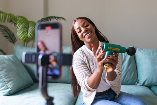 Black woman recording secondhand app listing from home