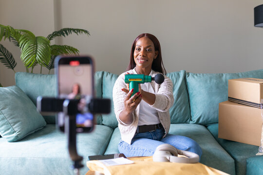 Black woman recording secondhand app listing from home