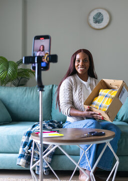 Black woman selling secondhand clothing on app via livestream