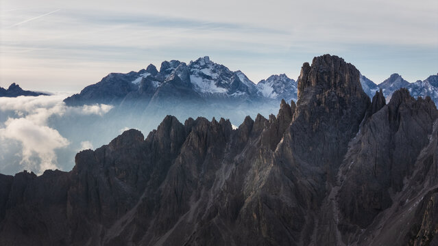 Aerial view of Cadini group mountain peaks rising above a sea of clouds under a soft sky Auronzo di Cadore, Veneto, Italy.