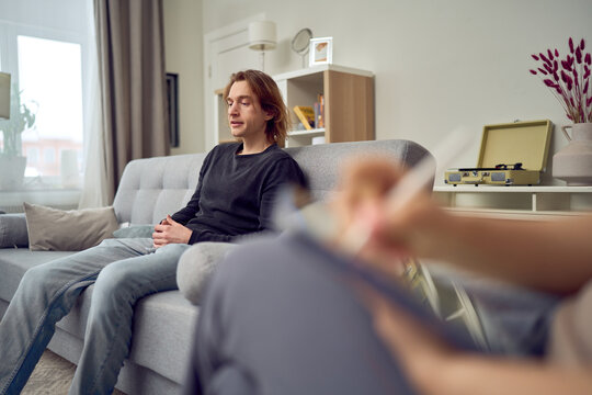 Male client explaining problem during therapy session indoors