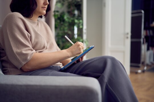 Closeup of therapist taking digital notes during counseling