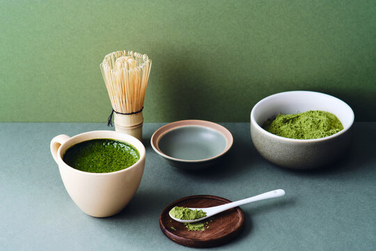 Matcha tea with bamboo whisk in minimalist composition