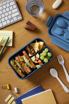 Healthy bento lunchbox with sandwich and fruit on desk