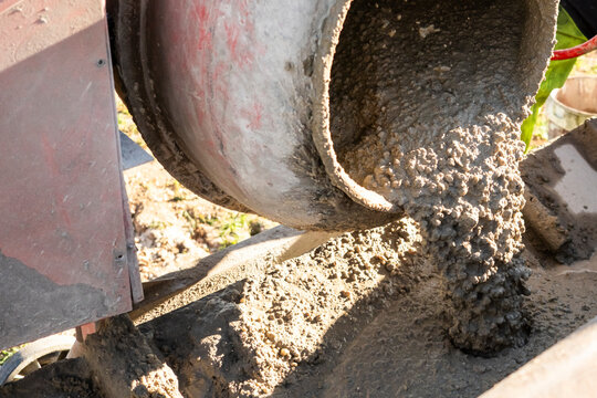 Fresh concrete pouring from cement mixer at exterior site