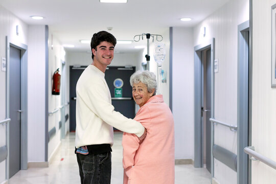 Elderly patient with visitor in hospital corridor