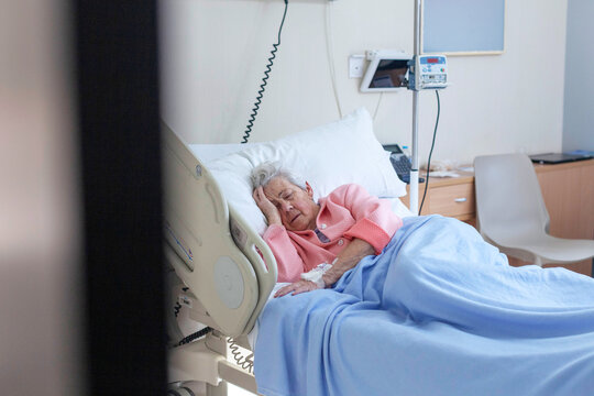 Elderly patient resting in a hospital bed with medical care
