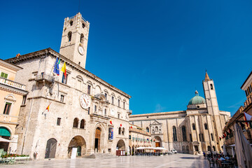 Obraz premium Piazza del Popolo featuring the Palazzo dei Capitani del Popolo and San Francesco church under a clear sky, showcasing historic Italian architecture and popular tourist destination