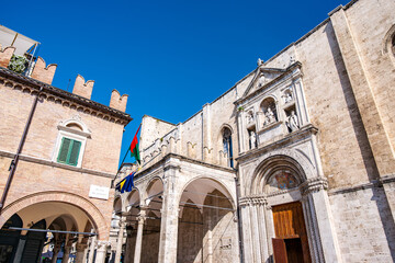Fototapeta premium Historic piazza in Ascoli Piceno with the Palazzo dei Capitani and San Francesco church along the logge, medieval and Renaissance facades under a clear blue sky