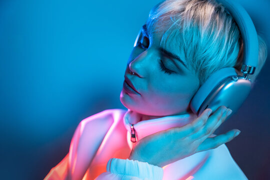 Futuristic woman listening to music in neon blue light