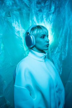Futuristic woman in blue neon light with headphones