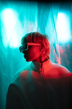 Futuristic woman in neon light wearing visor in studio