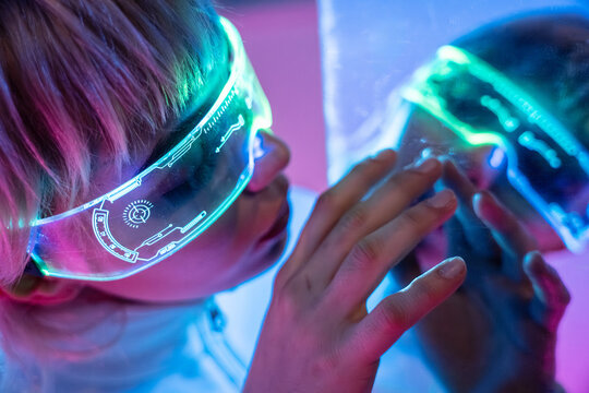 Futuristic woman using neon visor in cyberpunk light