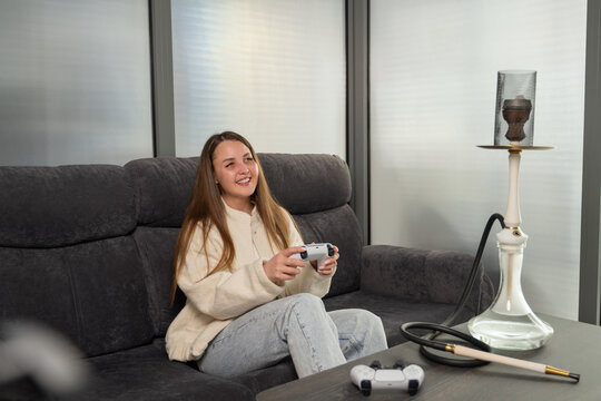 Girl relaxing with video game and hookah at bar setting