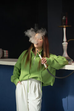 Girl enjoying hookah in a modern bar setting