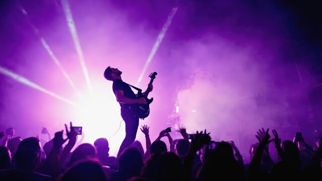 Energetic Male Rock Musician Performing Live on Stage with Intense Lighting and Enthusiastic Audience.