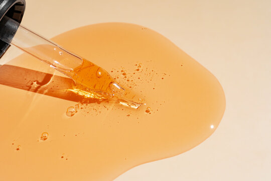 Amber gel shampoo texture with dropper on clean surface