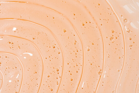 Peach shower gel texture background with glossy bubbles