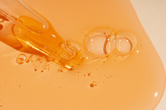 Amber shower gel texture background with bubbles and dropper