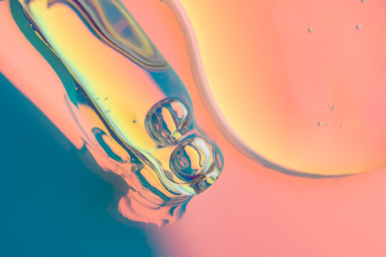 Cosmetic serum drop macro in neon lighting background