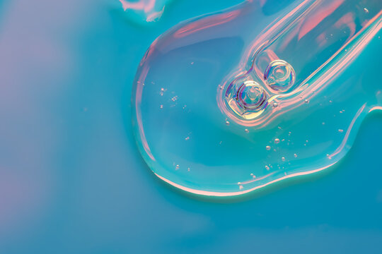 Cosmetic serum drop with glass dropper in neon lighting