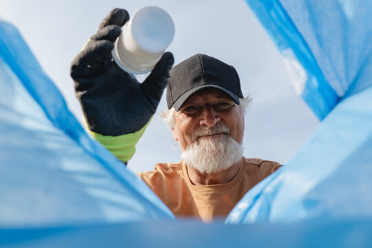 Senior volunteer collecting plastic for community cleanup