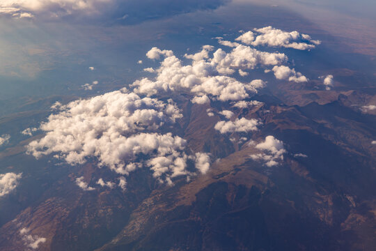 Aerial view of clouds drifting above rugged mountainscape