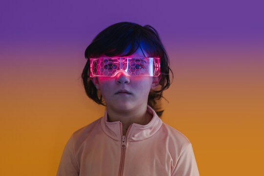 Kid wearing neon VR visor exploring future technology