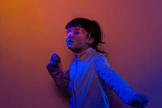 Child in neon tech goggles imagining a futuristic world