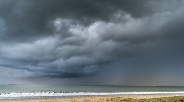 Dark storm clouds over sandy beach and sea, &Icirc;le de R&eacute;, France