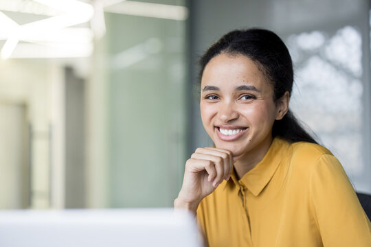 Confident young woman smiling in modern office setting