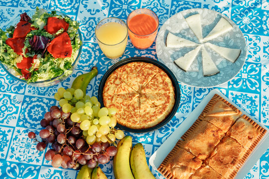 Summer picnic table with fruit, pastries, and fresh juice