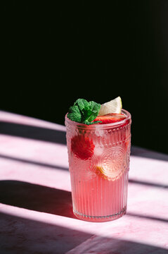 Strawberry lemonade in embossed glass with mint garnish
