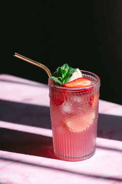 Refreshing strawberry lemonade in a glass with mint and ice