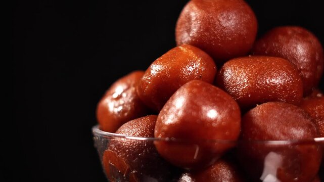 Gourmet Indian Sweet Food Videography - Glossy Gulab Jamun Dumplings Macro View. Popular Festive Indian Sweet Mithai.