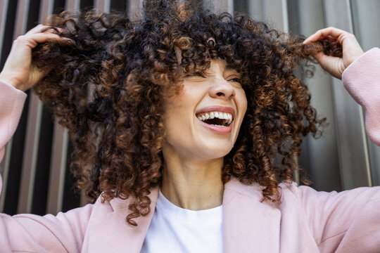Joyful Hispanic woman embracing curly lifestyle