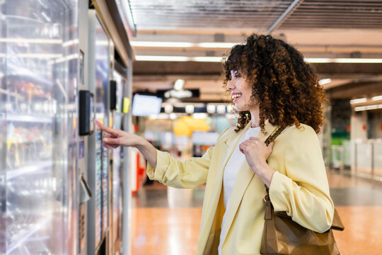 Hispanic woman choosing at a vending machine