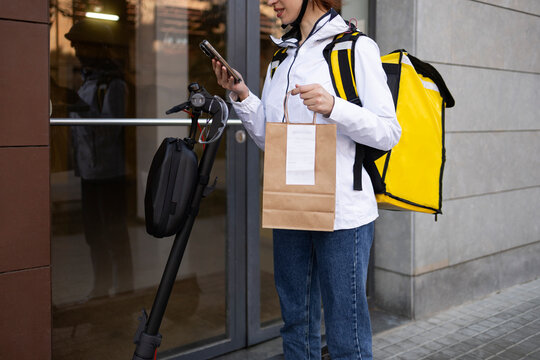 Female food delivery rider with scooter and takeaway bag