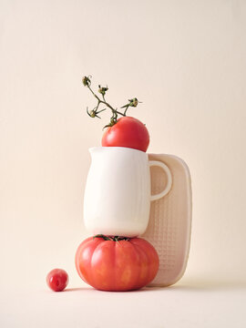 Minimal tomato still life with white jug and plate on light