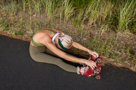 Woman stretching with roller skates on Australian path