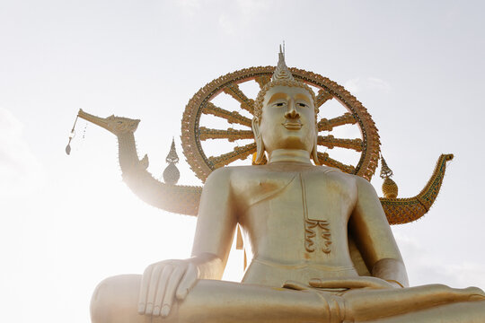 Golden buddha statue at Thai temple, tropical travel scene